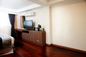 a bedroom with a bed and a flat screen tv at Poste 43 Residence in Bangkok