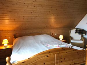a bed in a wooden room with two lamps at Ferienwohnung mit Garten in Wieck