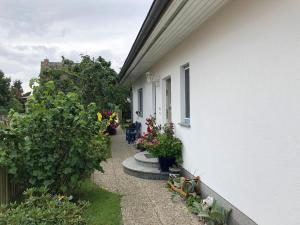 a side walk with flowers and plants next to a house at Ferienwohnung mit Garten in Wieck