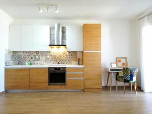 a kitchen with white cabinets and a black oven at Maiv Apartments in Rogoznica