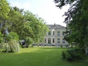 a large white house with trees in the yard at chateau de Pougy in Pougy