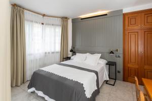 een slaapkamer met een groot bed en een raam bij Hotel Panadeiramar in Sanxenxo
