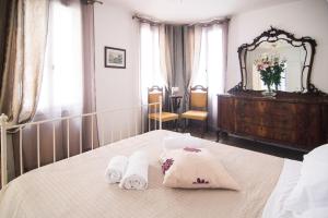 een slaapkamer met 2 handdoeken op een bed met een spiegel bij Cà Lina in Venetië