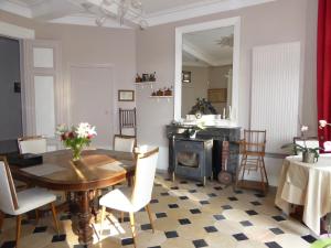 a dining room with a table and a fireplace at chateau de Pougy in Pougy