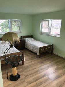 a room with two beds and a table and two windows at COMMUNE hotel in Garni