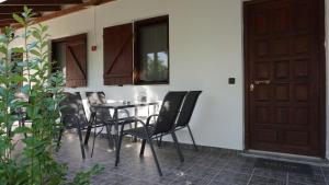 a patio with a table and chairs next to a door at Sivota Colours in Sivota