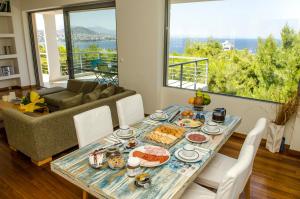 einen Tisch mit Essen darauf im Wohnzimmer in der Unterkunft Villa Serenity in Porto Rafti