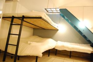 パリにあるUnusual, cosy 20m² BATIGNOLLES districtの二段ベッド1組、はしごが備わる客室です。