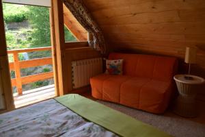 カルパチにあるLeśniówka Domki W Karpaczuのベッド1台と椅子1脚が備わる客室です。
