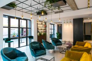 a lobby with couches chairs and tables and windows at Horti 14 Borgo Trastevere in Rome