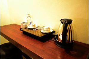 a table with a tea kettle and a tray with dishes at The One Residence in Udon Thani