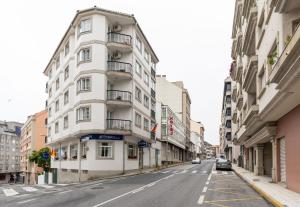 ein weißes Gebäude an der Straßenseite in der Unterkunft Hotel Panadeiramar in Sanxenxo