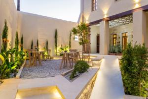 cortile con tavoli, sedie e piante di Aelios Design Hotel a Chania