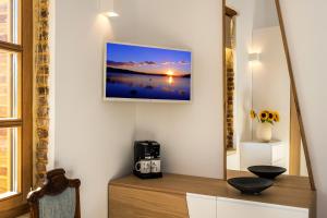 a room with a mirror and a tv on the wall at Aelios Design Hotel in Chania Town