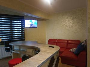 ein Wohnzimmer mit einem roten Sofa und einem Fernseher in der Unterkunft Apartament Loft Beach SummerlandRomania in Mamaia