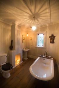 a bathroom with a tub and a toilet and a sink at Coghill Cottage in Whitianga