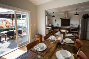 a kitchen and dining room with a wooden table at Coghill Cottage in Whitianga