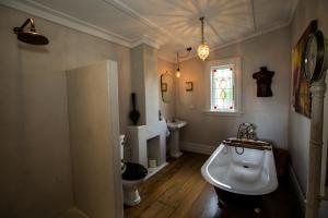 a bathroom with a white tub and a sink at Coghill Cottage in Whitianga