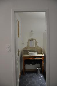La salle de bains est pourvue d'un lavabo et d'un miroir. dans l'établissement La Petite Maison Rouge, à Mèze