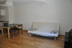 Kleines Zimmer mit einem Bett und einem Tisch in der Unterkunft La Petite Maison Rouge in Mèze