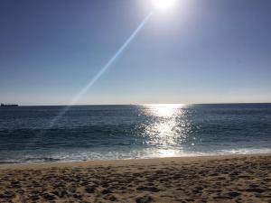 a beach with the sun shining on the water at Departamento Viña del Mar in Viña del Mar