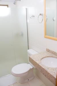a bathroom with a toilet and a sink at Hotel Pallis in Erechim