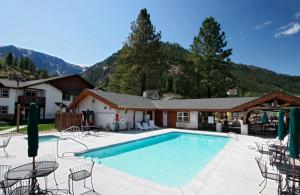 a swimming pool with chairs and a house at Icicle Village Resort in Leavenworth