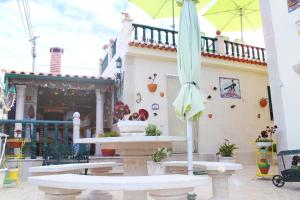 a patio with a fountain and an umbrella at Moradia Meca - Casas para Férias in Nazaré