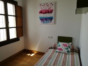 サンルーカル・デ・バラメダにあるApartamento Aldama en el centro de Sanlúcar de Barramedaのベッドルーム1室(枕付)