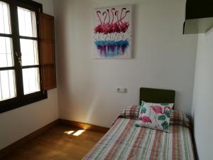 een slaapkamer met een bed met een kussen erop bij Apartamento Aldama en el centro de Sanlúcar de Barrameda in Sanlúcar de Barrameda