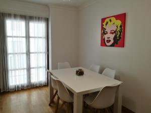 een eetkamer met een witte tafel en stoelen bij Apartamento Aldama en el centro de Sanlúcar de Barrameda in Sanlúcar de Barrameda