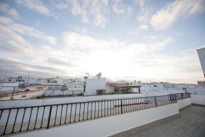 a balcony with a view of a city with white buildings at Factory Rooms Barbate in Barbate