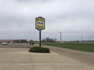 a sign for a parking in innrosis on a street at Prairie Rose inn in Edgeley