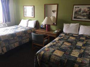 a hotel room with two beds and a desk at Prairie Rose inn in Edgeley