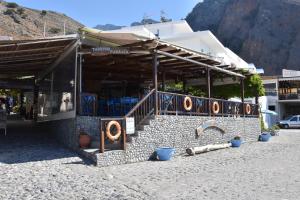 um edifício com um restaurante ao lado de uma montanha em Paralia guest house em Agia Ruméli