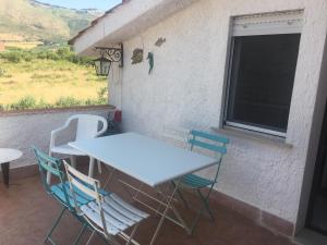 un tavolo e sedie su un patio con finestra di Villino Fraginesi a Castellammare del Golfo Altre 37 foto
