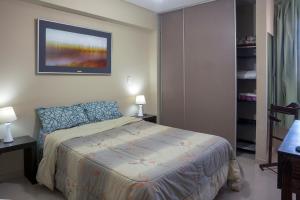 ein Schlafzimmer mit einem Bett und einem Wandgemälde in der Unterkunft Apart Bicentenario in San Miguel de Tucumán