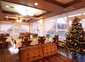 a christmas tree in the dining room of a restaurant at Akakura Yours Inn in Myoko