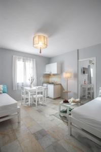 um quarto branco com duas camas e uma mesa em Ippokampos Town Apartments em Naxos Chora
