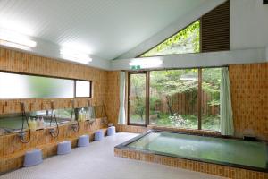a large bathroom with a swimming pool and a large window at Yamanakako-Asahigaoka-Onsen Hotel Seikei in Yamanakako