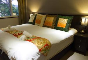 um quarto com 2 camas com almofadas e uma janela em Ski-in, Ski-out Iwatake Apartments em Hakuba