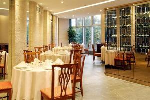 a restaurant with tables and chairs with white tablecloths at Central Hotel Shanghai in Shanghai