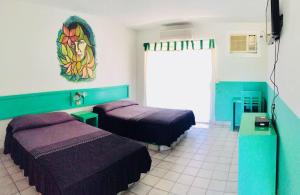 Zimmer mit 2 Betten und Wandgemälde in der Unterkunft Hotel y R.V. Park El Moro in Loreto