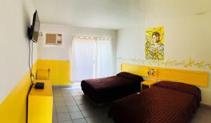 Cette chambre comprend 2 lits et une fenêtre. dans l'établissement Hotel y R.V. Park El Moro, à Loreto