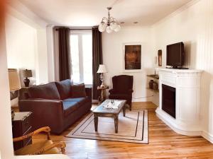 a living room with a couch and a fireplace at La Ruelle Hébergement in Saint-Siméon