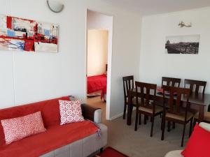 ein Wohnzimmer mit einem roten Sofa und einem Esszimmer in der Unterkunft PUQ Rent Apartment in La Serena