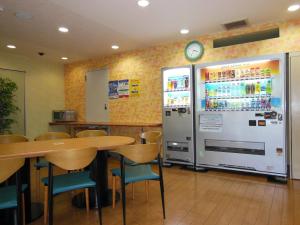 Smile Hotel Kakegawa في كاكِغو: مطعم فيه ثلاجة وطاولة وكراسي