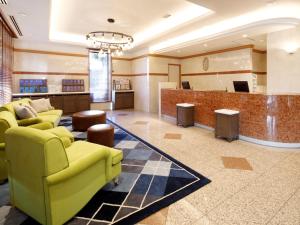 a lobby with a waiting room with yellow furniture at HOTEL MYSTAYS Maihama in Urayasu
