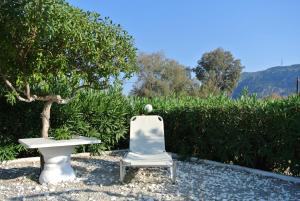 a white chair sitting next to a table and a bench at Kokalakis Hotel in Kefalos