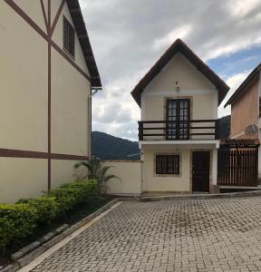 a white house with a balcony and a driveway at Chale Zen in Penedo